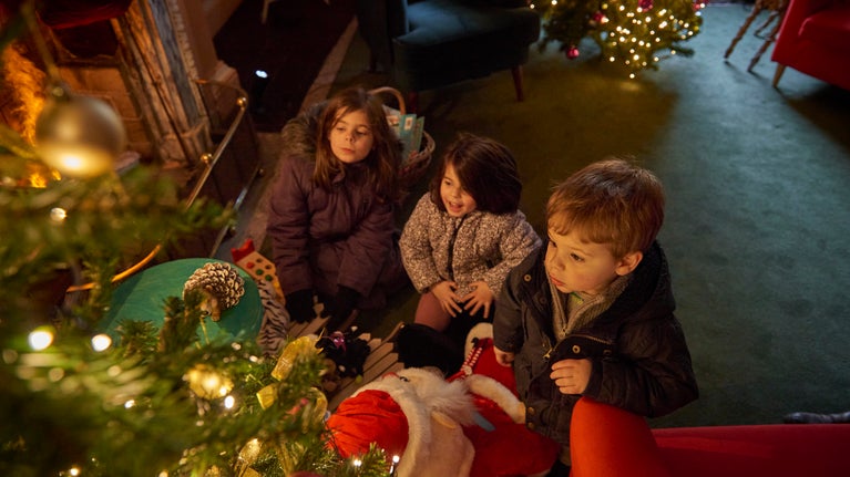 Three children looking up at Christmas tree inside Ormesby Hall